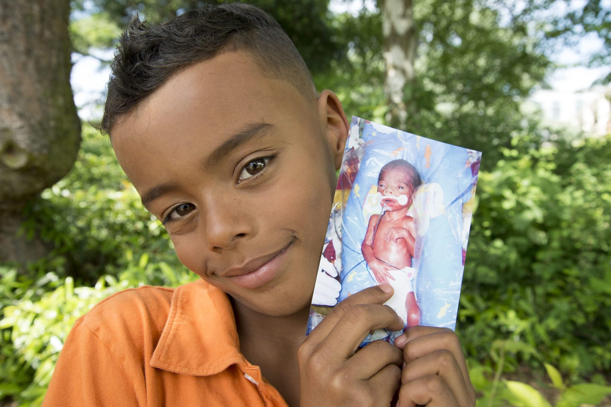 Quincy Surprenant holds a photo of himself in the NICU