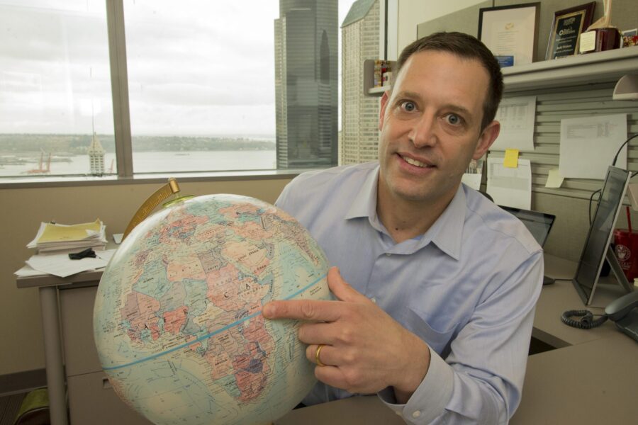 photo of Judd Walson pointing to Africa on a globe