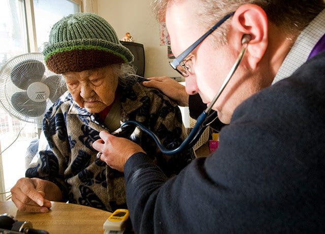 UW Medicine palliative care specialist Darrell Owens checks a patient's breathing.