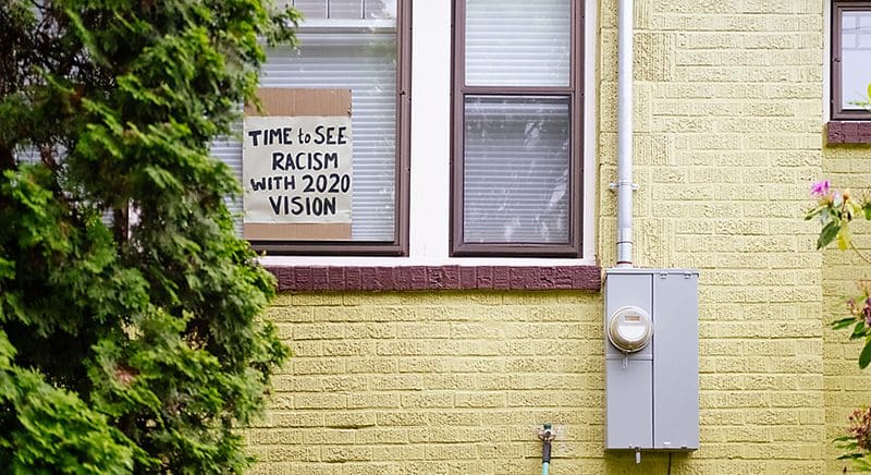a house with a sign in the window that says "Time to See Racism with 2020 Vision"