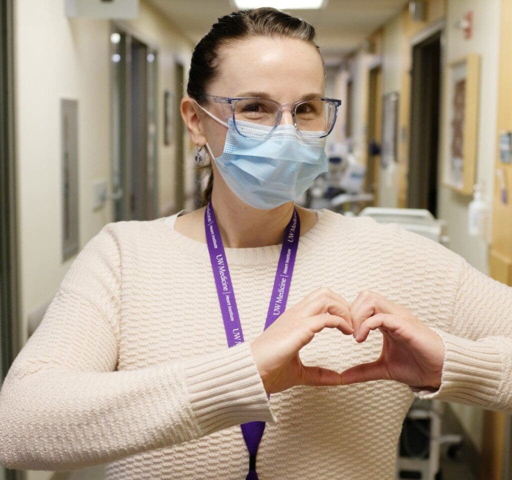 Heart Institute Employee makes hand heart