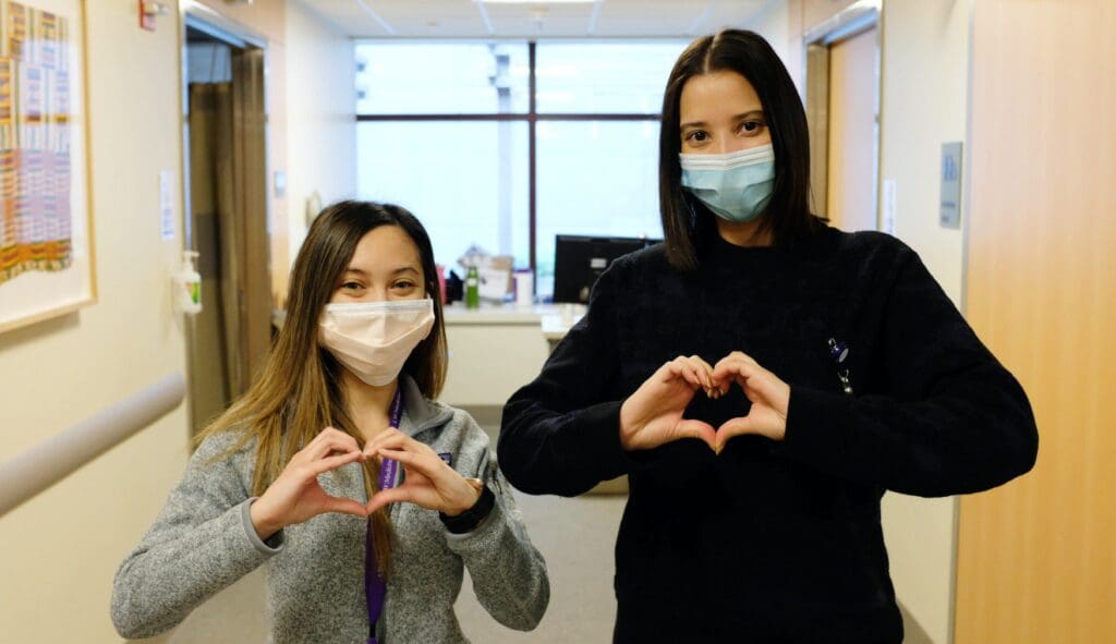 Heart Institute employees making hearts with hands