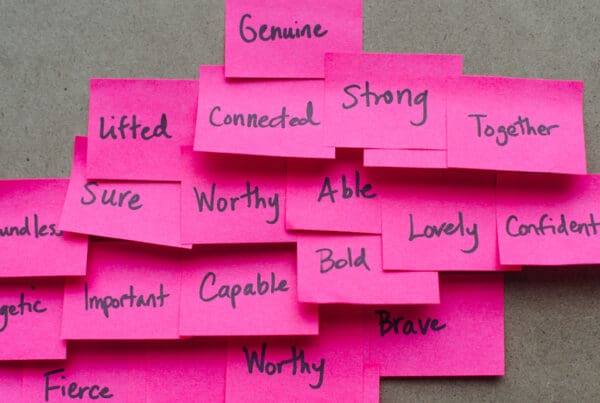 An image of pink sticky notes with positive affirmations written in black