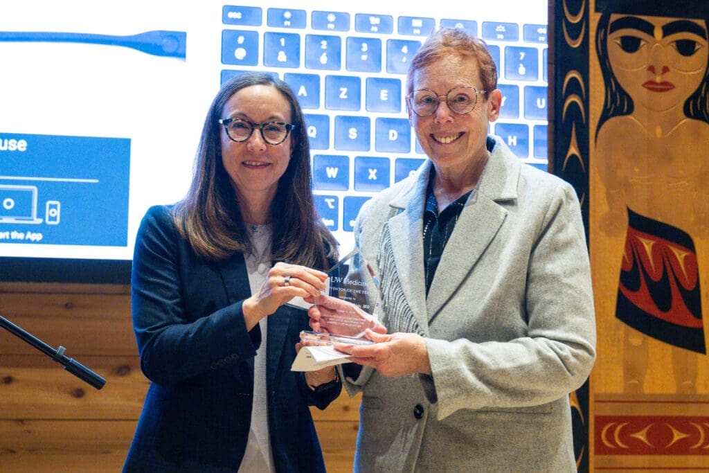 Disis and Sakiyama-Elbert holding the award on stage.